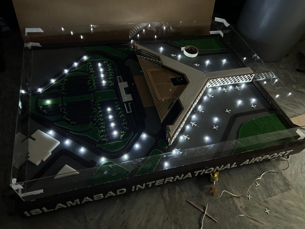Islamabad International Airport physical model with landscaped car park, access roads and terminal inside a glass display case