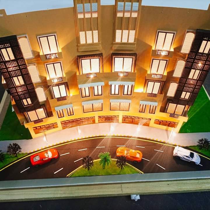 Front elevation of the Business Center model in Riveria, Bahria Phase 7, with shop fronts, road, palm trees and model cars