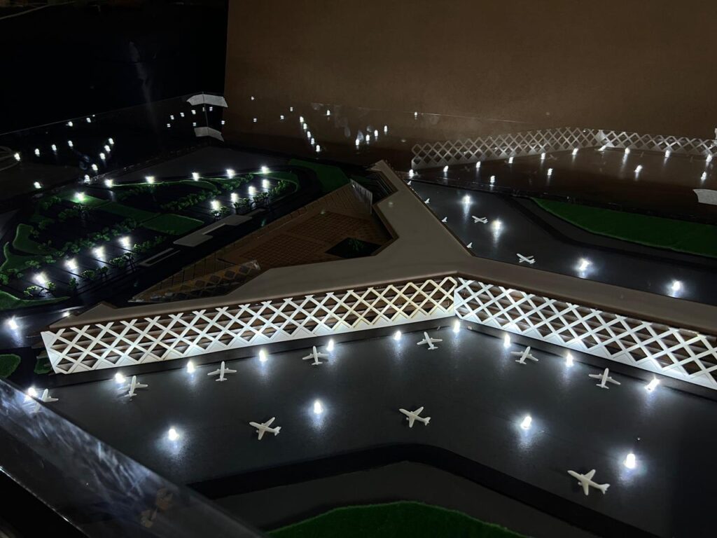 Physical scale model of the Islamabad International Airport terminal with its lattice façade, lit apron and model aircraft, made for FWO