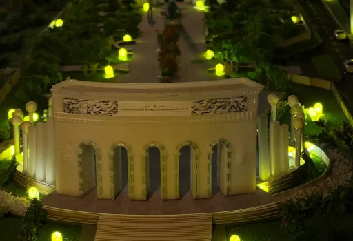 Illuminated physical model of the Marka-e-Haq Pakistan monument with its arched facade, raised plaza and garden lights